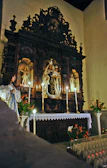 A serene candlelit altar dedicated to the Virgin Mary during a nighttime prayer service