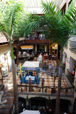 A bustling multi-level pet mall atrium filled with happy pets and their owners exploring vibrant shops and play areas.