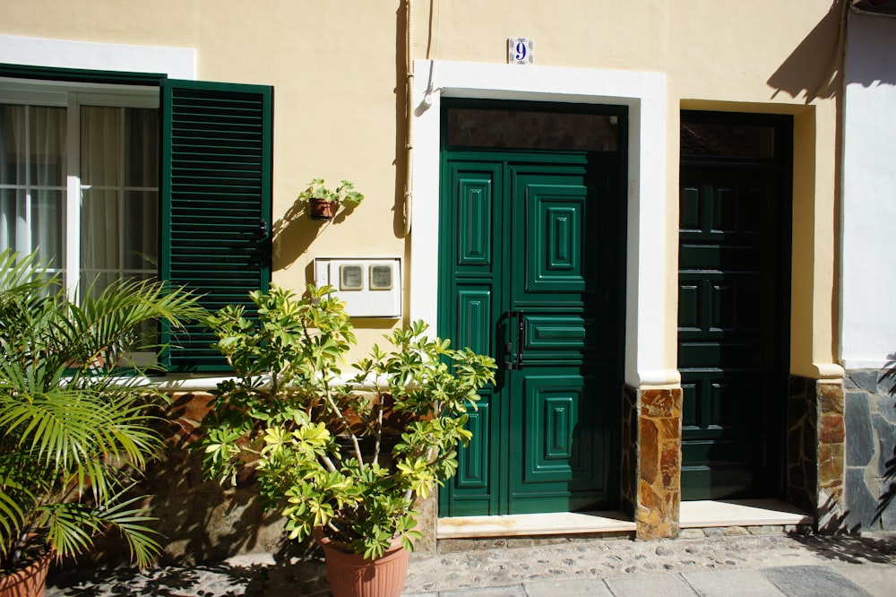 a building with green shutters and a green door