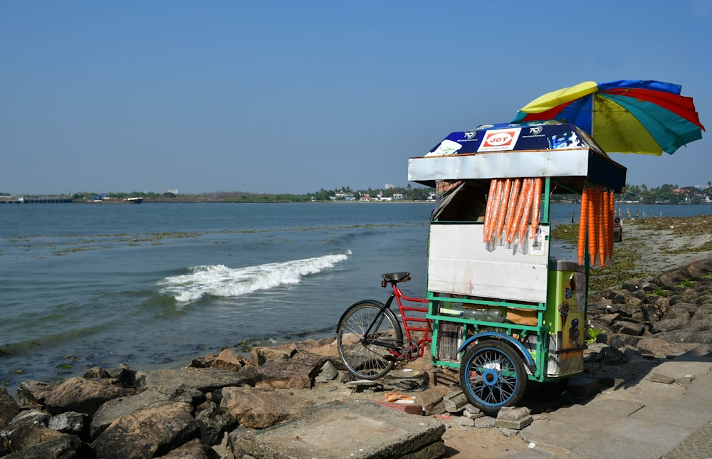 a bike is parked next to a small ice cream cart