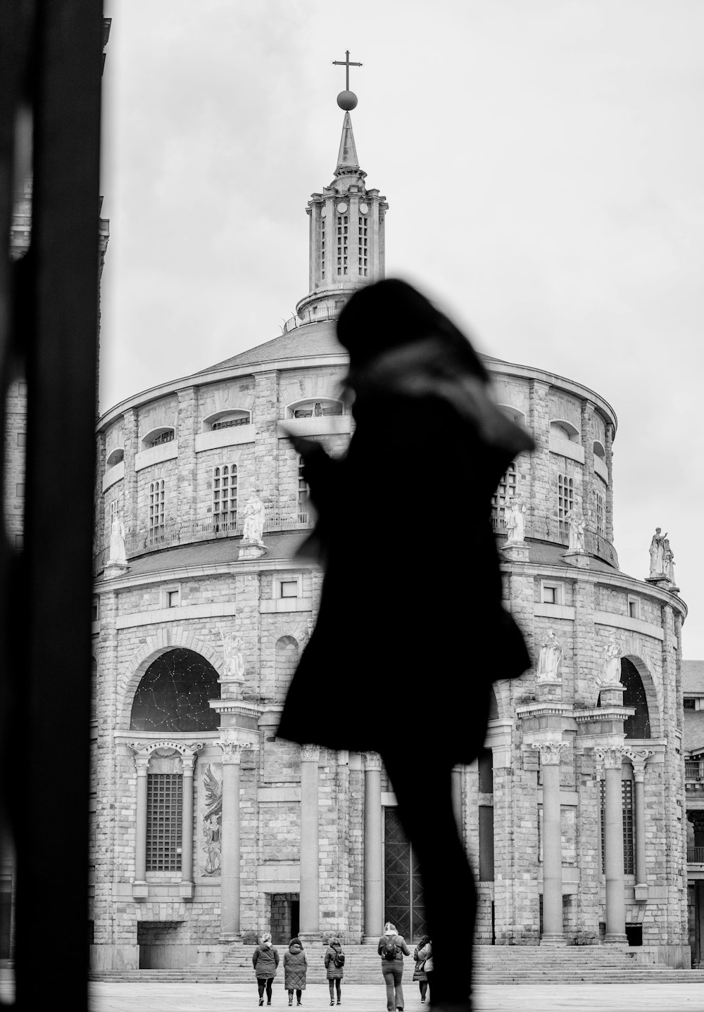 a black and white photo of a person standing in front of a building