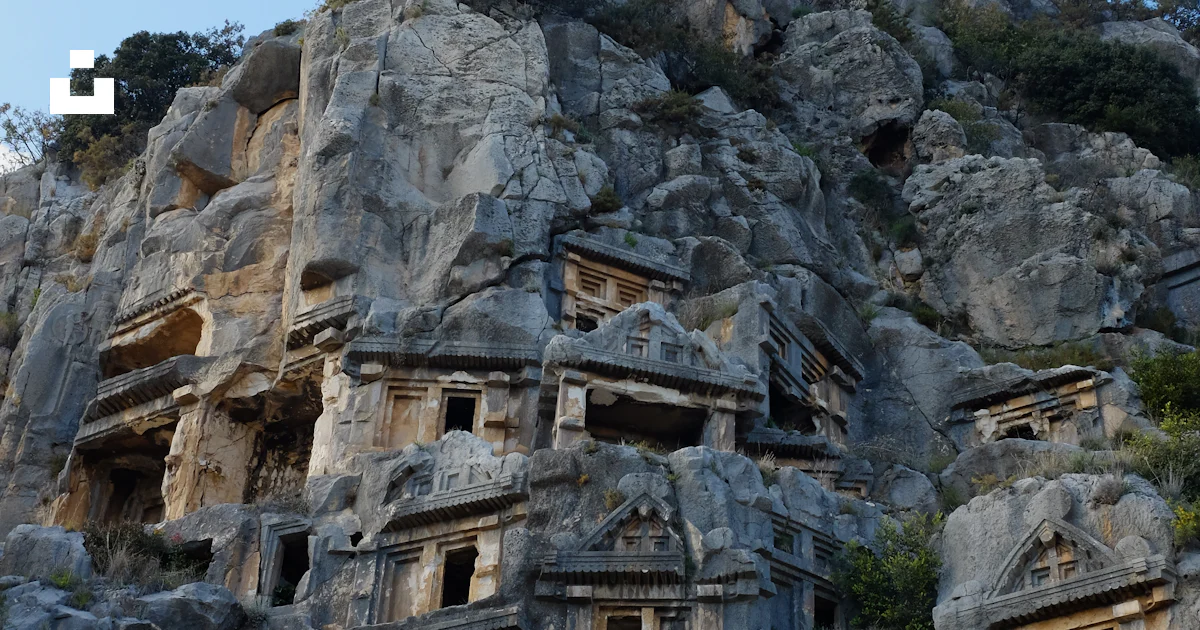 A large rock formation with a bunch of buildings built into it photo ...