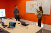 a man and a woman standing in front of a whiteboard