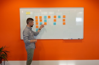 a man standing in front of a white board