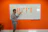 A man pointing at a whiteboard filled with colorful process steps during a meeting.