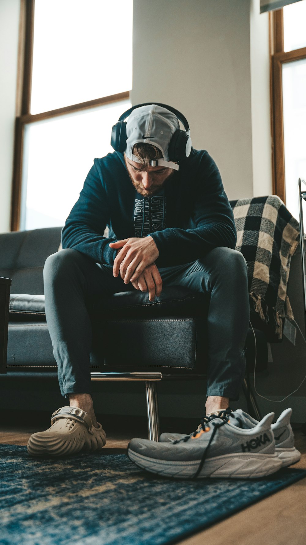 a man sitting on top of a couch next to a pair of shoes