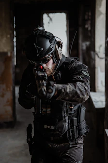 A focused instructor guiding a small group through tactical firearm drills against a dark, moody backdrop with red accents.