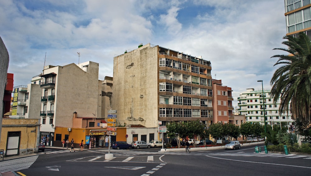 a city street with tall buildings and palm trees