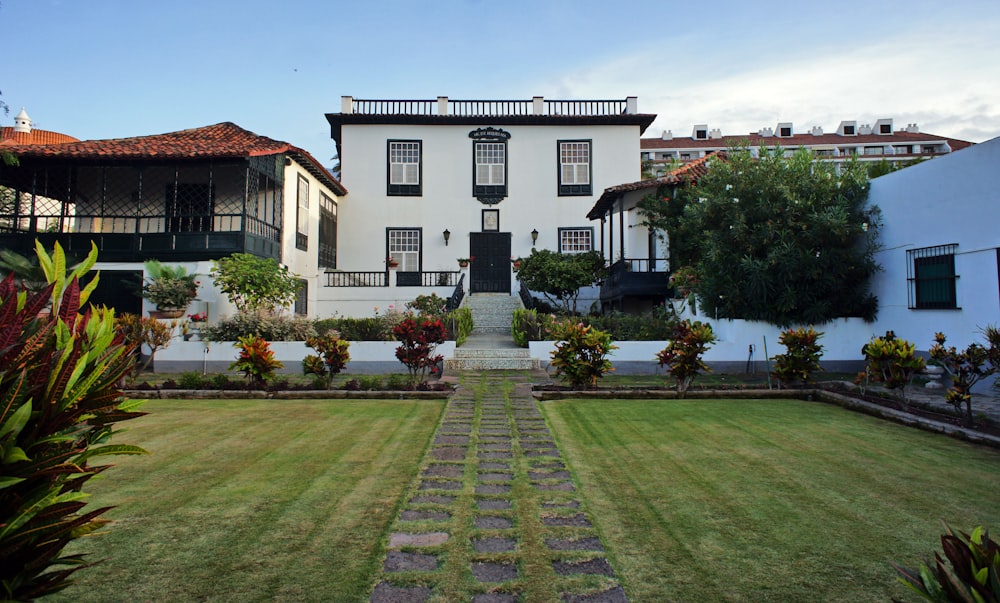 a large white house with a garden in front of it