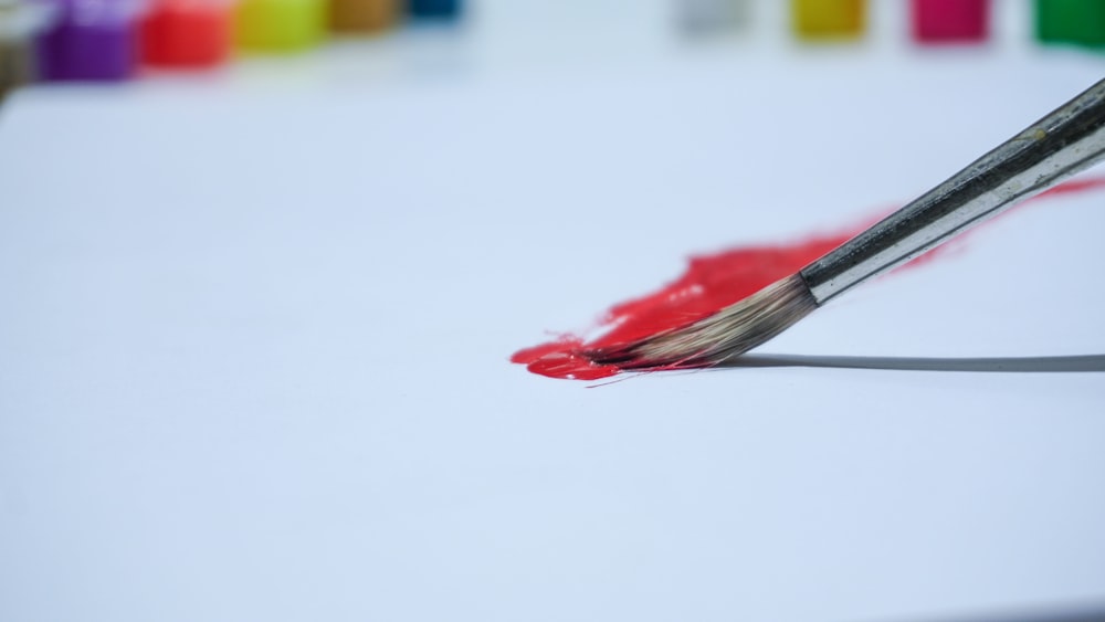 a close up of a paintbrush with red paint