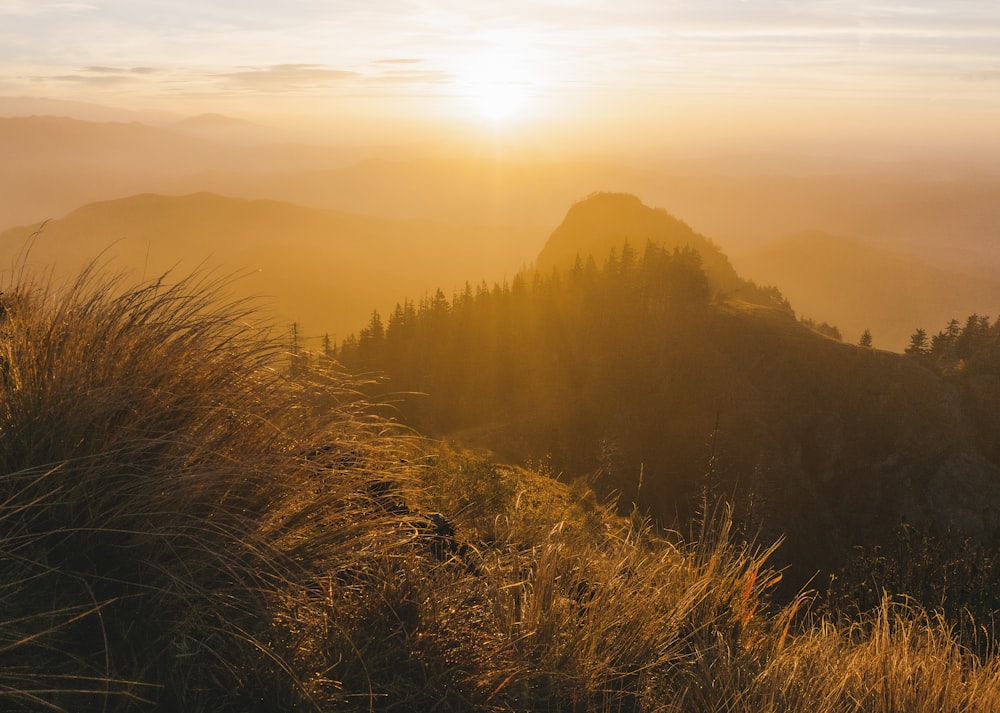 the sun is setting over a mountain range