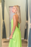 A happy customer trying on a blouse in a dressing room.