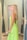 A happy customer trying on a fashionable dress in a bright fitting room.