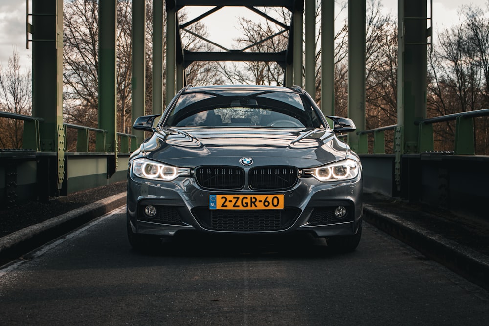 a silver car is driving on a bridge