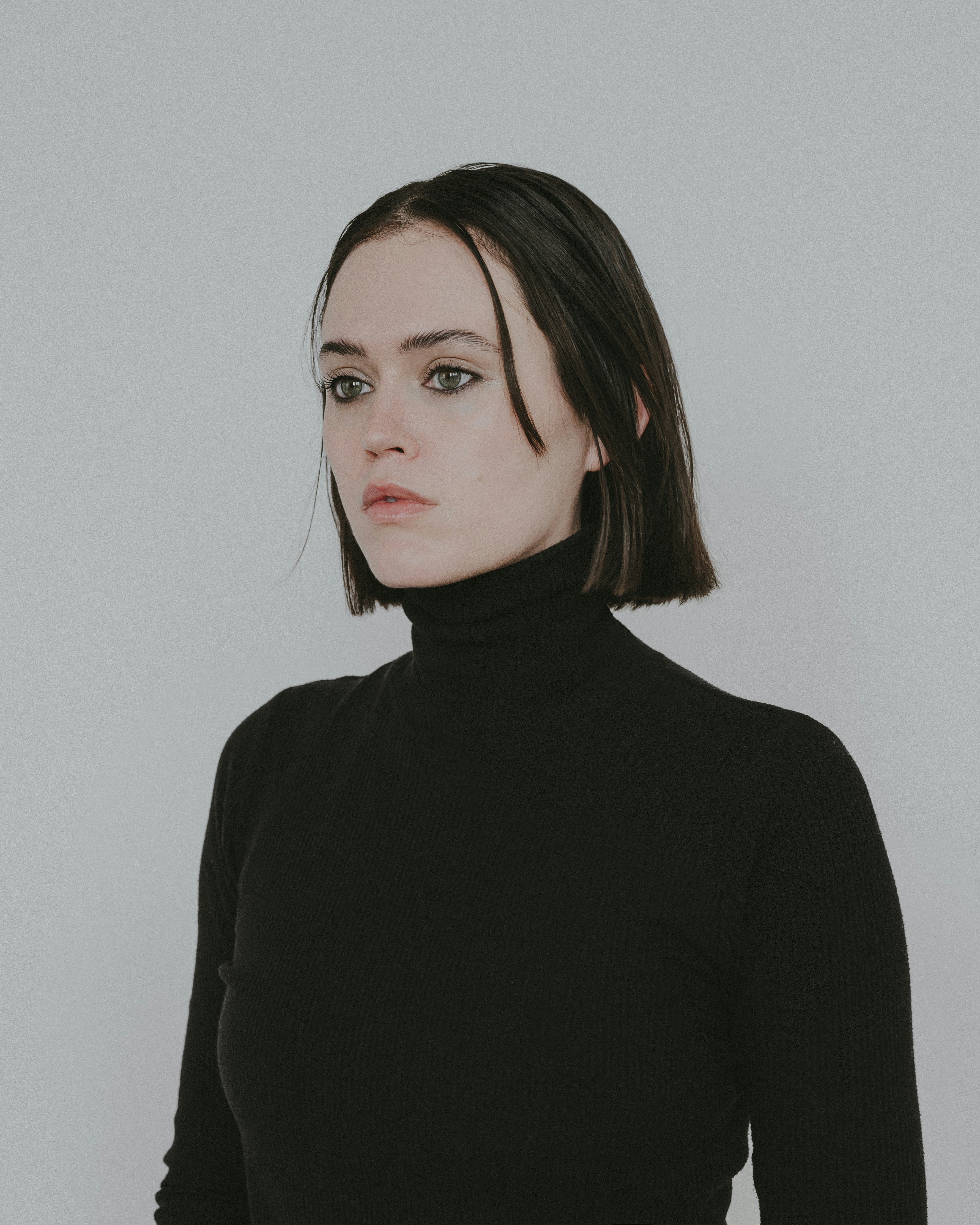 a woman wearing a black turtle neck sweater