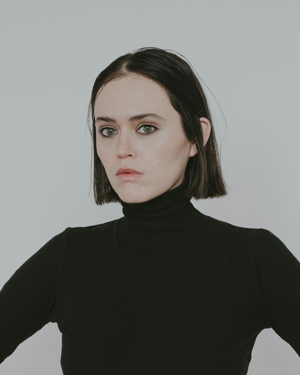 a woman wearing a black turtle neck sweater