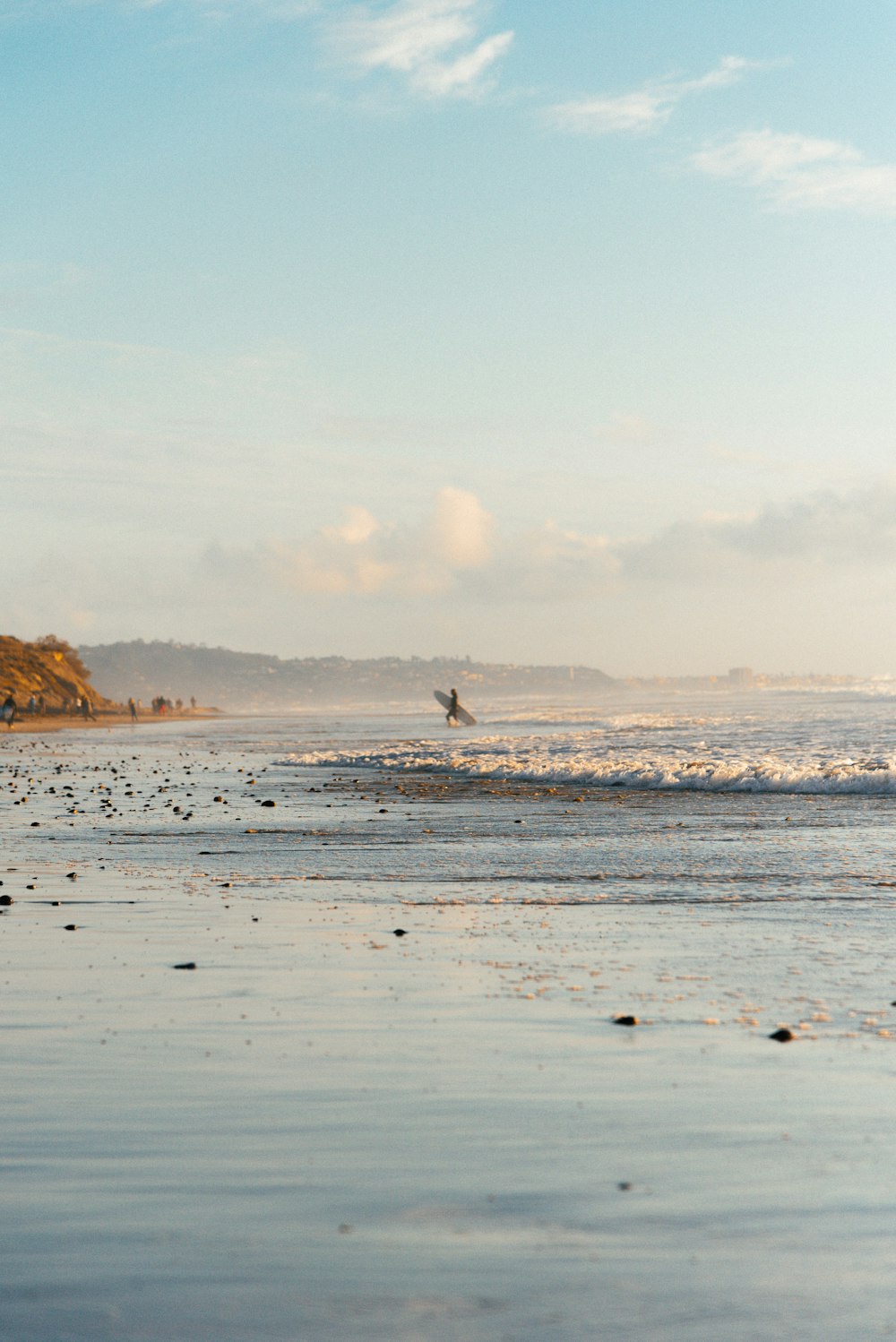 a person walking on a beach with a surfboard