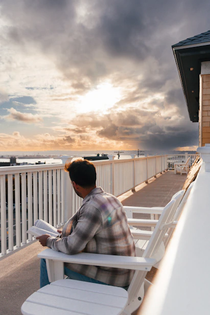 a person sitting on a bench reading a book