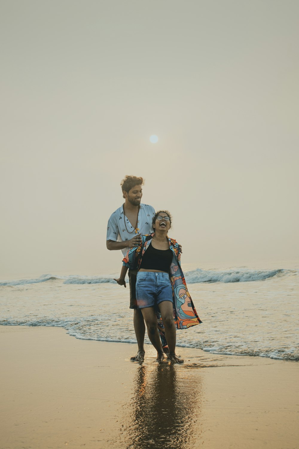 Un hombre y una mujer caminando por la playa