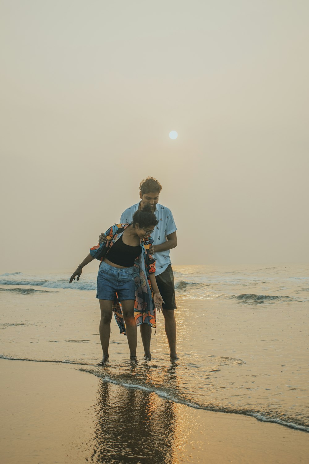 a couple of people that are standing in the sand