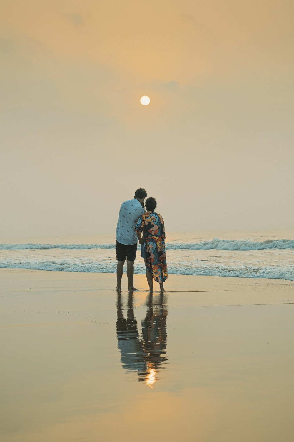 a couple of people standing on top of a beach