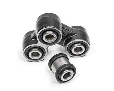 Close-up of heavy machinery parts including bushings and pins arranged neatly.