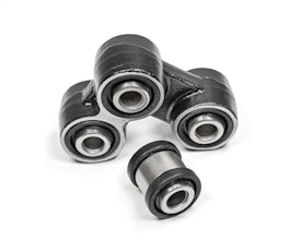 A close-up of metal mechanical components consisting of multiple rubber bushings. The bushings are primarily black with a metallic silver inner ring and are set against a plain white background.