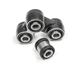 A close-up of metal mechanical components consisting of multiple rubber bushings. The bushings are primarily black with a metallic silver inner ring and are set against a plain white background.