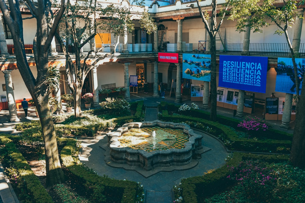 a courtyard with a fountain surrounded by trees