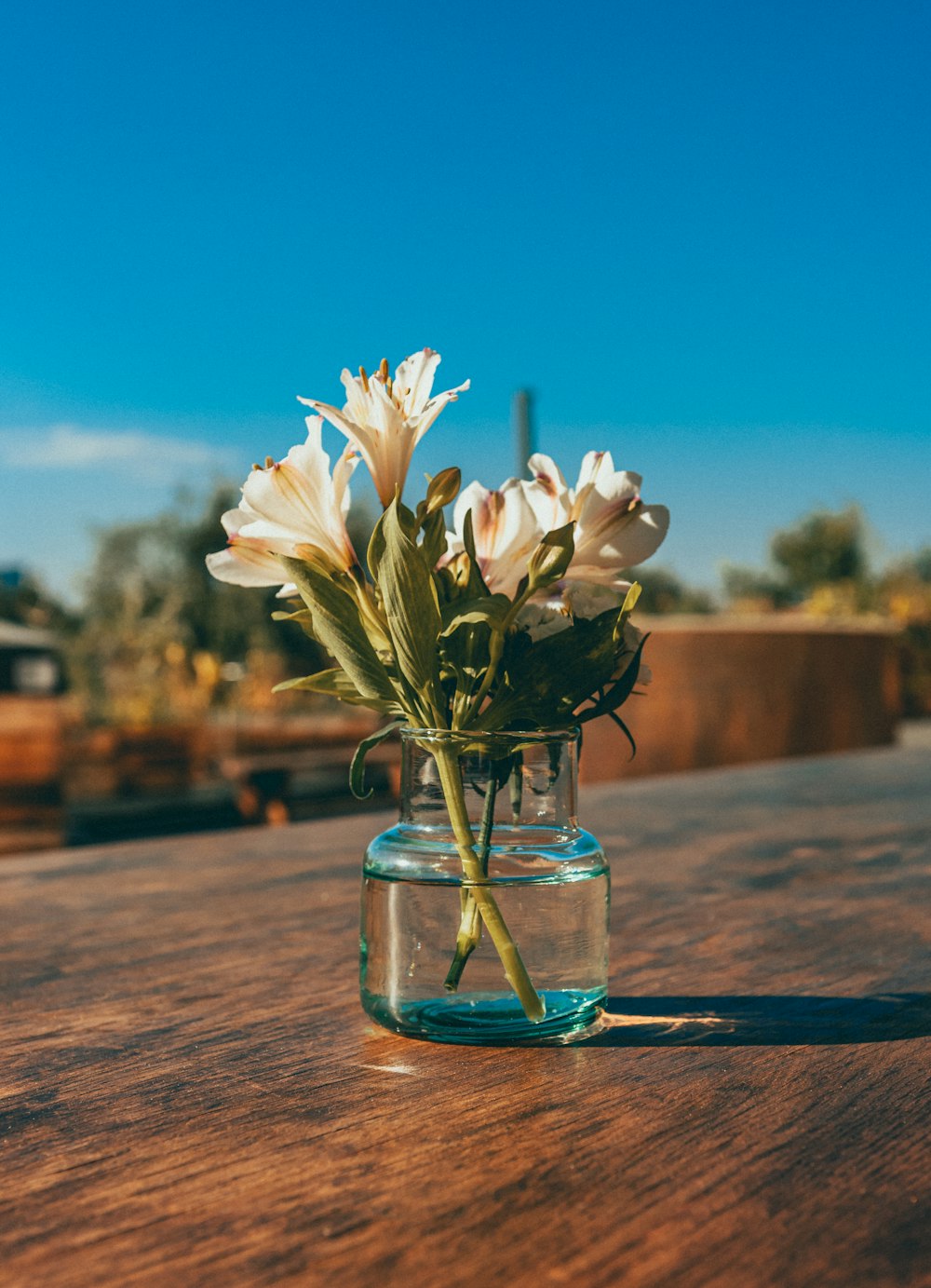 a glass jar with flowers in it sitting on a table