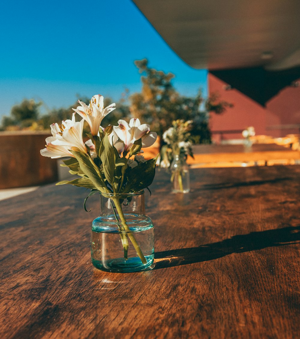 uma mesa de madeira coberta com vasos cheios de flores