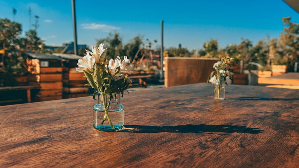 a wooden table topped with a vase filled with flowers