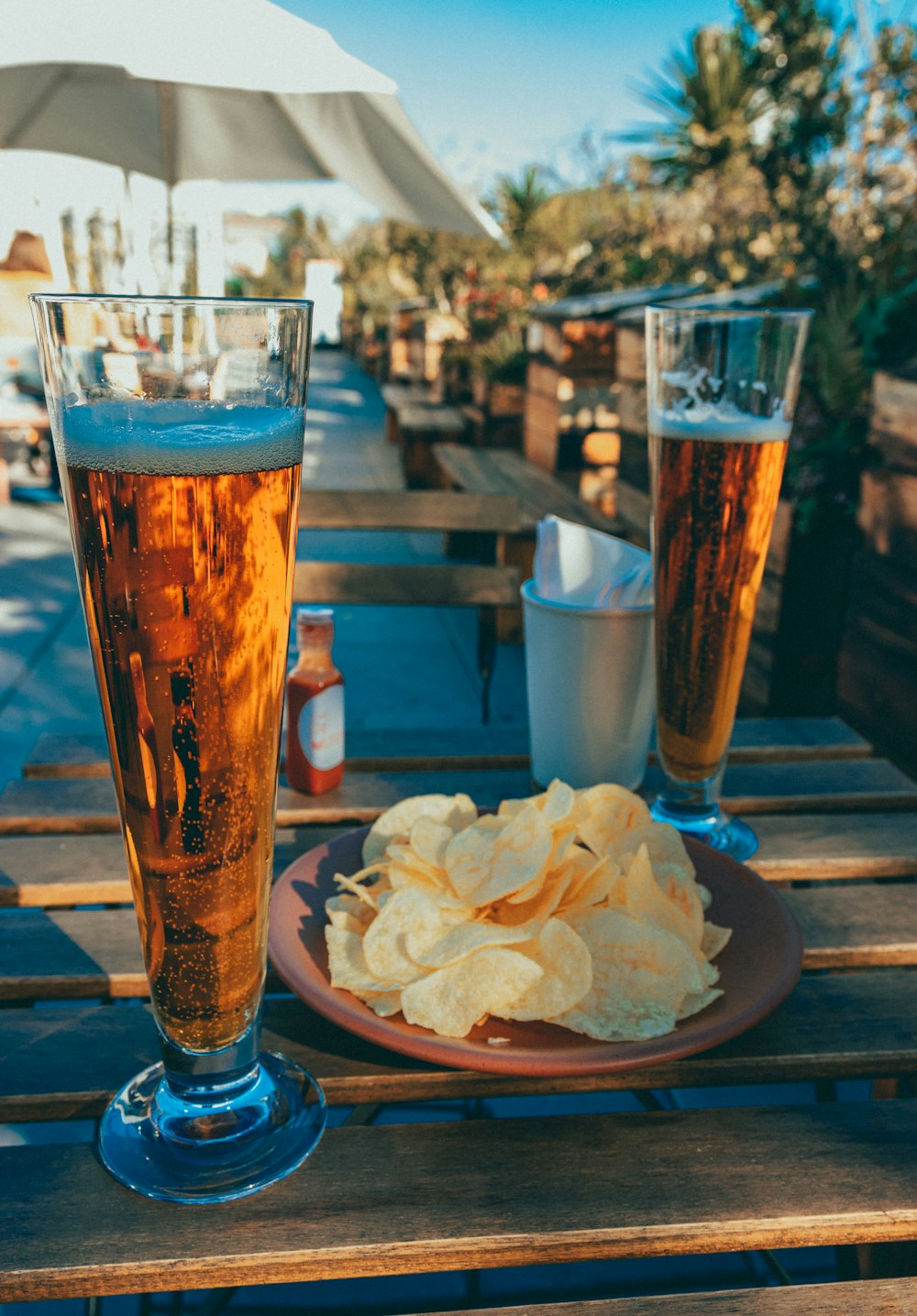 um prato de batatas fritas e um copo de cerveja em uma mesa