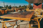 Elegant outdoor patio set with sleek chairs and a wooden table under soft natural light