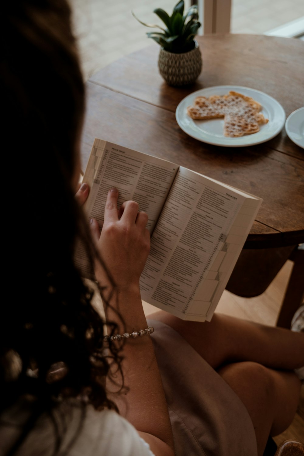 a woman sitting on a chair reading a book