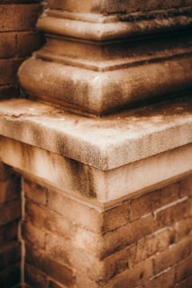 Detailed shot of a brick corner with layered stonework, showing textures of both smooth and rough surfaces. The perspective highlights the architectural design and craftsmanship.