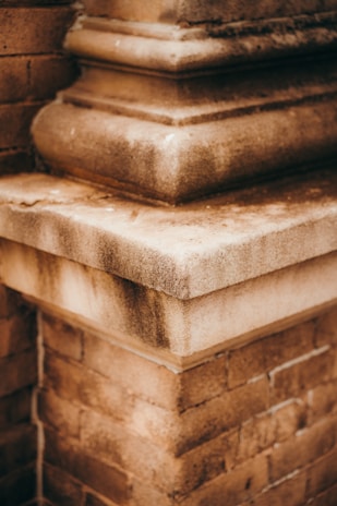 Detailed shot of a brick corner with layered stonework, showing textures of both smooth and rough surfaces. The perspective highlights the architectural design and craftsmanship.