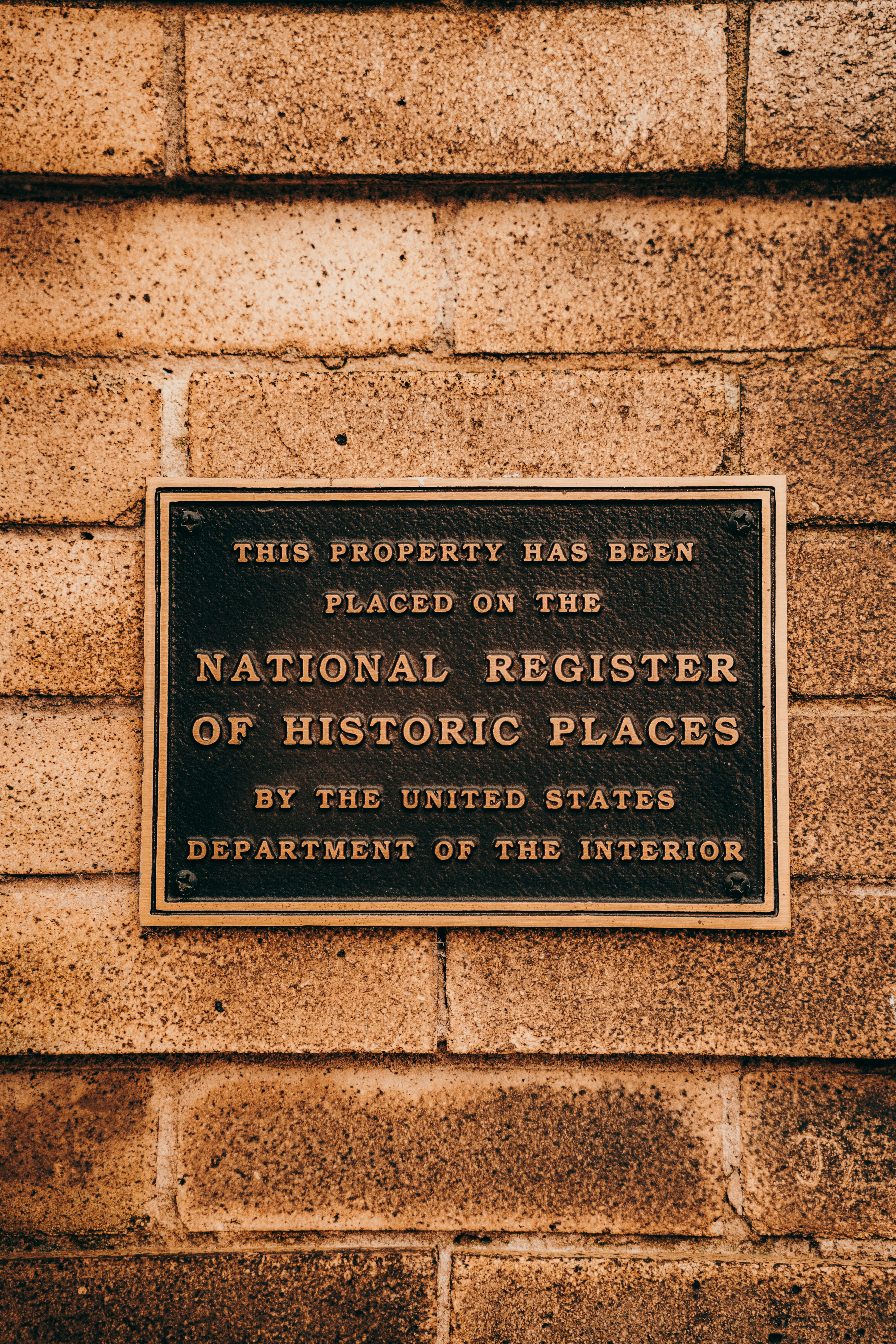 a brick wall with a plaque on it