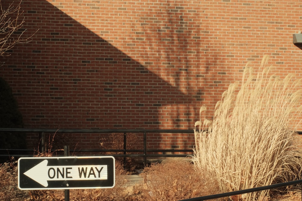 a one way sign in front of a brick building