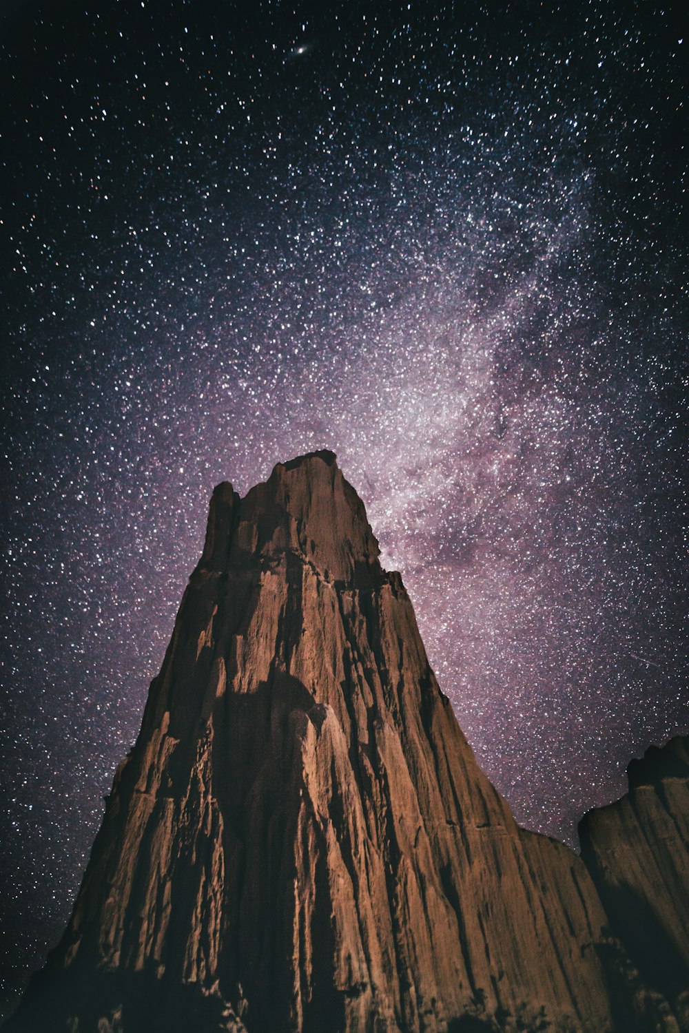 the night sky is filled with stars above a mountain