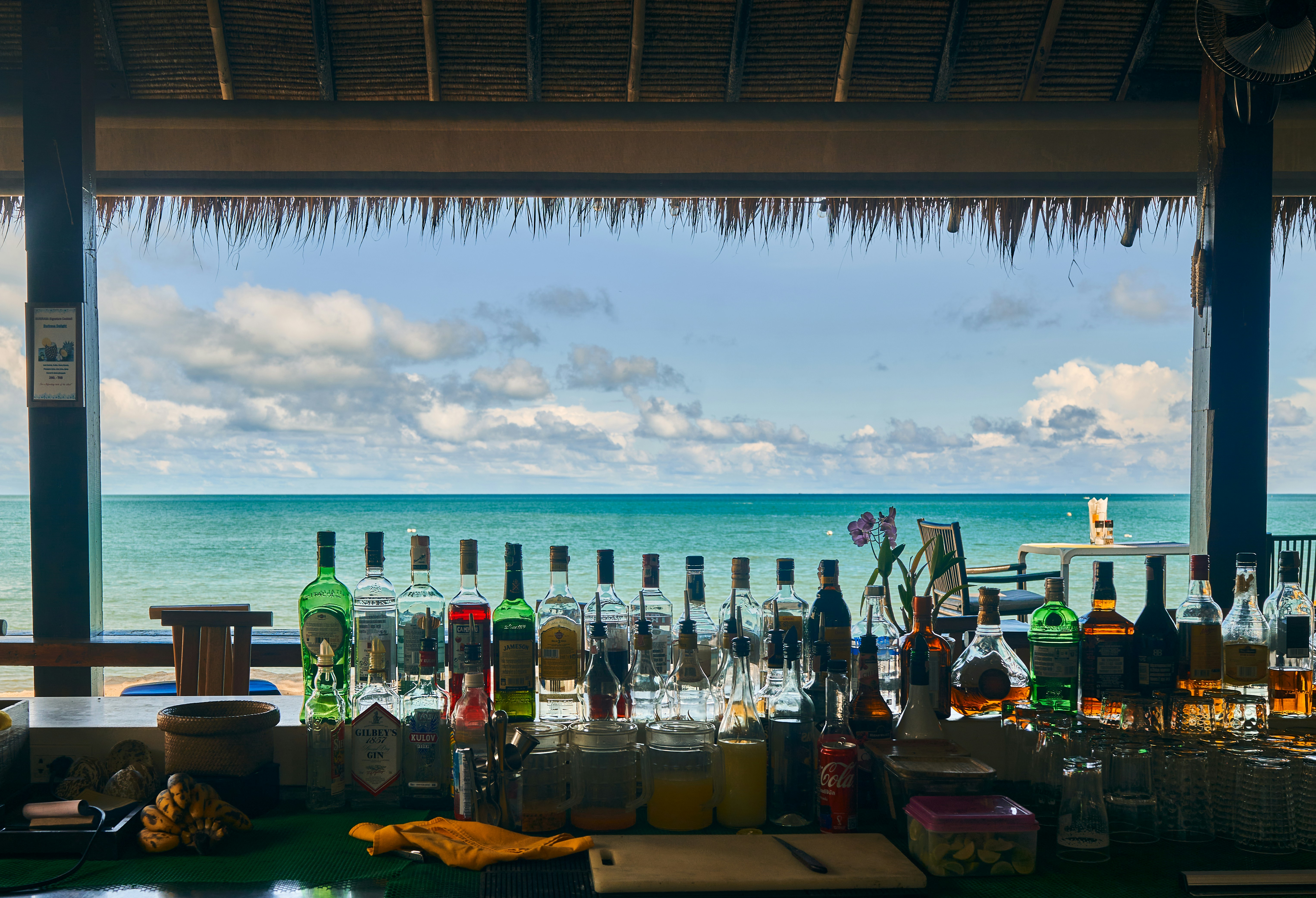 a bar with bottles of alcohol on the beach