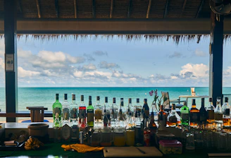 a bar with bottles of alcohol on the beach