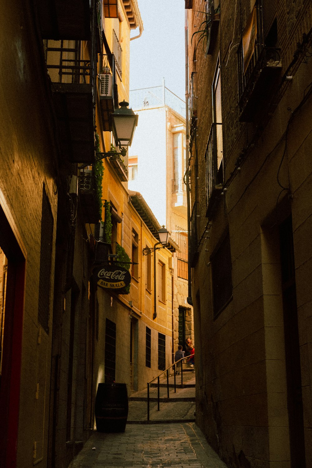 une ruelle étroite avec une valise sur le trottoir