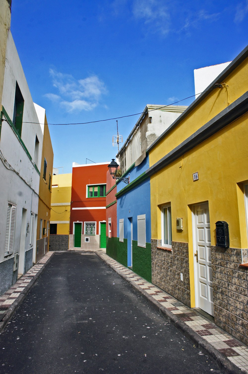 a narrow street with buildings painted in different colors