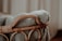 A textured, knit blanket is draped over the edge of a wicker basket. The scene is softly lit, creating a warm and cozy atmosphere.