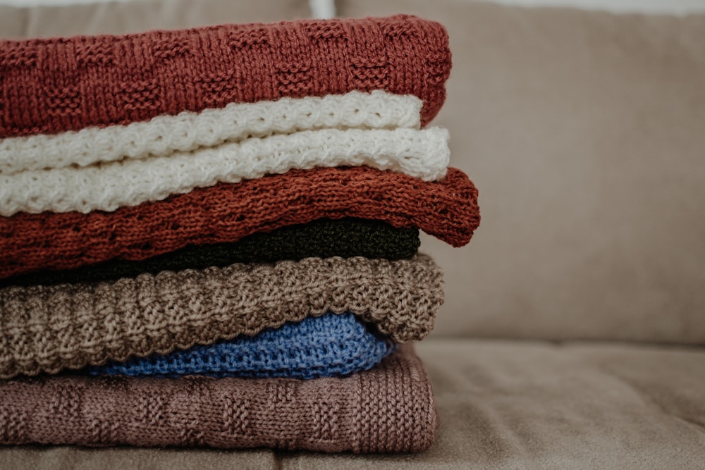 a stack of blankets sitting on top of a couch