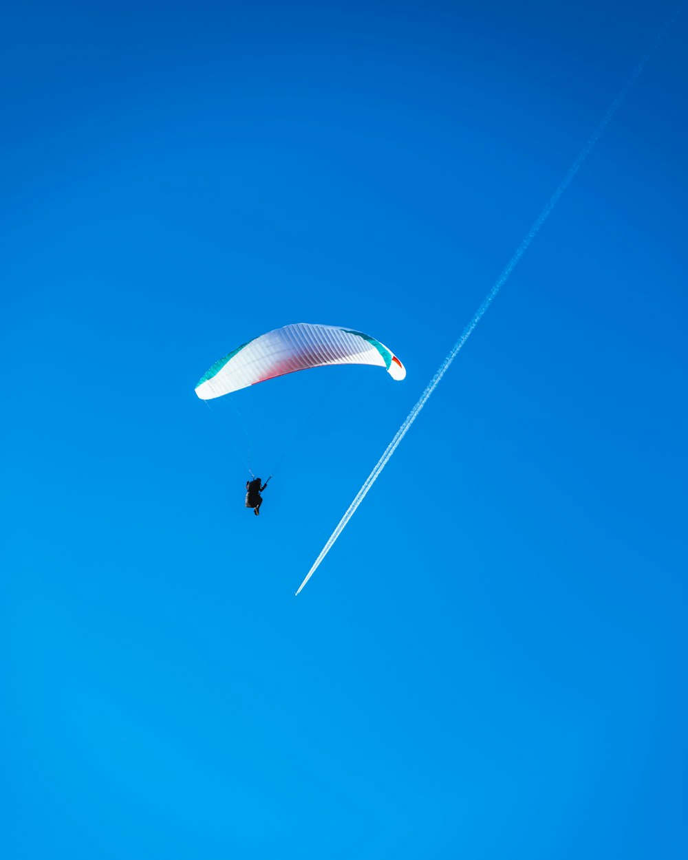 a paraglider is flying through the blue sky
