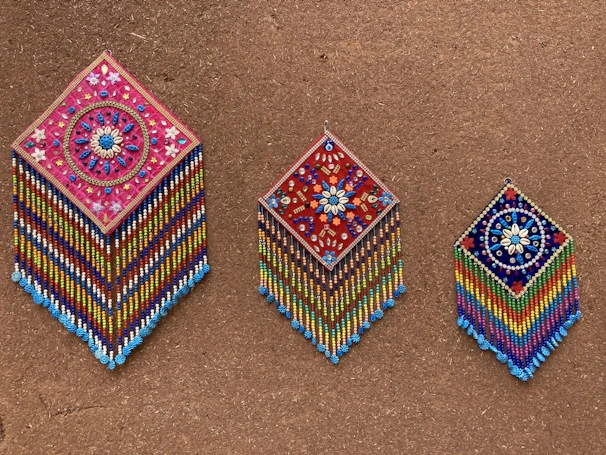 Handmade wall hangings with vibrant threads and beads reflecting Indian craftsmanship.