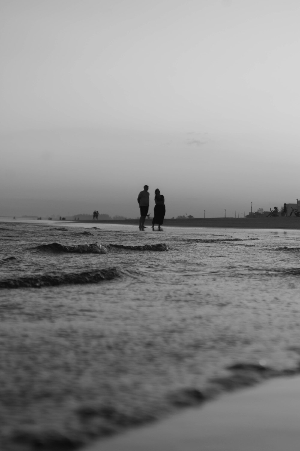 a couple of people standing on top of a beach