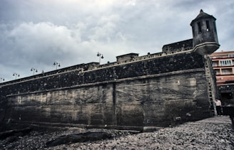 A fortified base with watchtowers and barricades under a stormy sky.